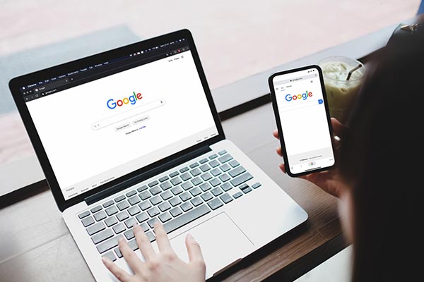 žena koristi gugl pretraživač na laptopu i telefonu